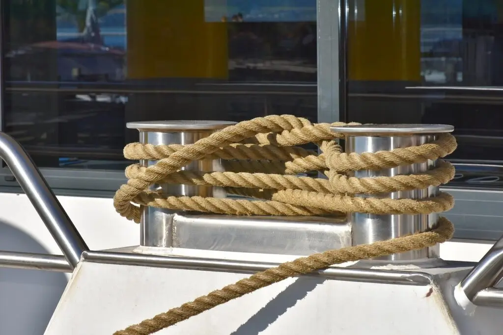 Dikke scheepstouwen belegd rond twee metalen bolders op een schip.